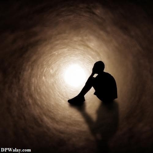 a person sitting in the middle of a dark tunnel