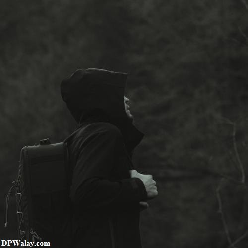 a man with a backpack walking through the woods alone love dp