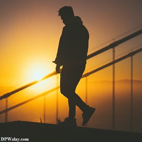 silhouette of a man walking on a bridge at sunset alone love dp 