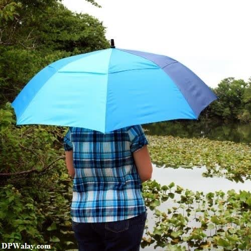 a person standing in the water holding an umbrella