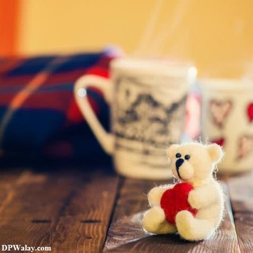 cute whatsapp dp - a teddy bear sitting on a wooden table next to a cup