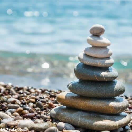 wallpaper for whatsapp dp - a stack of rocks on the beach