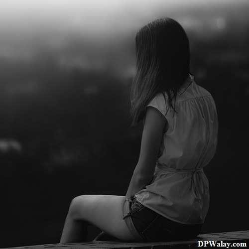 a woman sitting on a ledge looking out over the city best alone dp 
