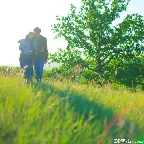 a couple walking through a field