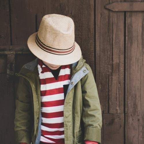 a little boy wearing a hat and jacket 