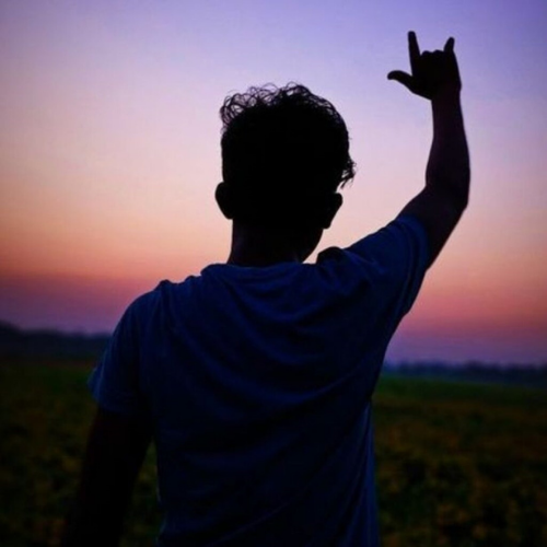 a man standing in a field with his hand up boys whatsapp dp 