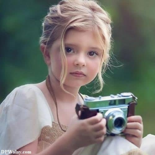 whatsapp dp cute baby girl - a little girl holding a camera in her hands