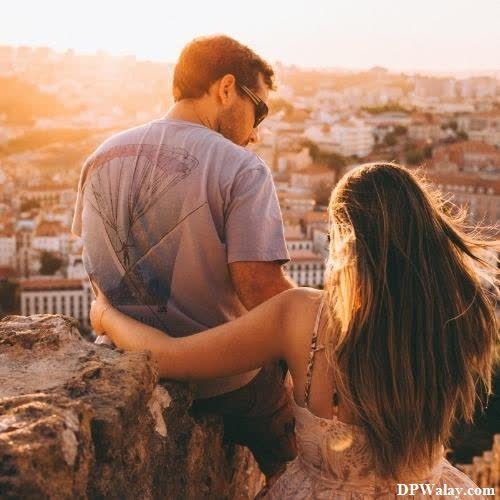 a man and woman sitting on a rock looking at the city couple dp whatsapp 