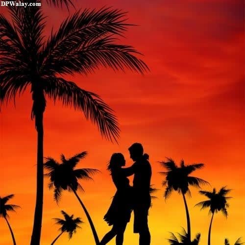 a couple kissing under a palm tree at sunset