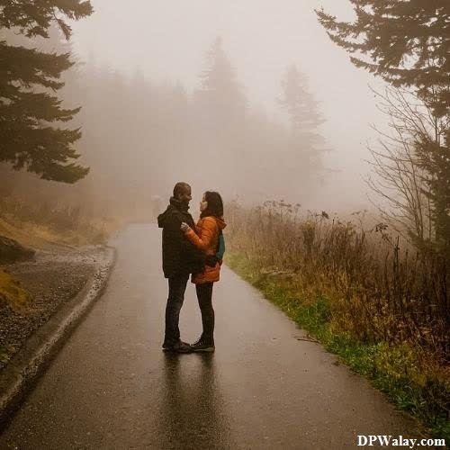 a couple standing on a road in the fog