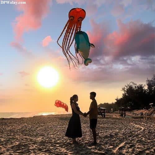 couple dp for whatsapp - a couple flying a kite on the beach