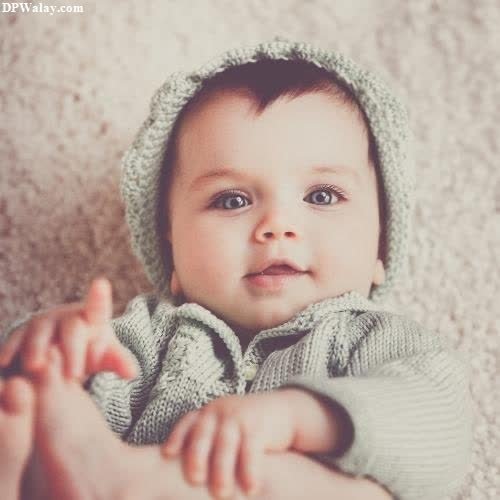 whatsapp dp cute baby girl - a baby in a knitted hat and sweater
