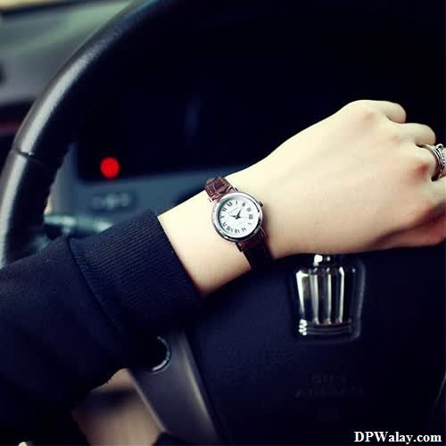 a woman is sitting in the car and holding a watch