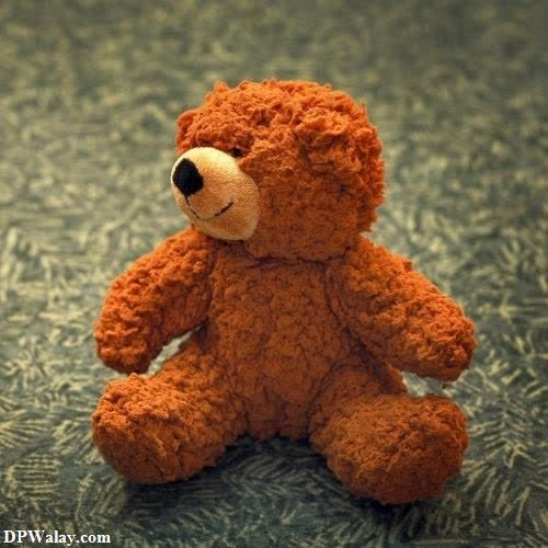 a teddy bear sitting on a carpet