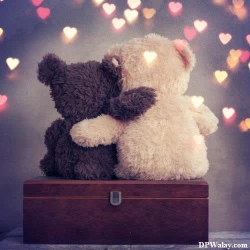 two teddy bears sitting on top of a wooden box images by DPwalay