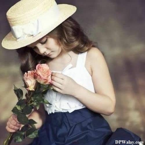 a little girl in a hat and dress holding a rose images by DPwalay