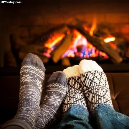 a person wearing socks and socks sitting in front of a fireplace cute love couple whatsapp dp