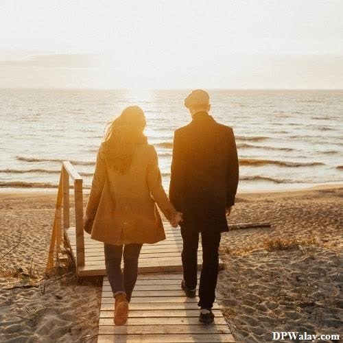 a couple walking down a wooden walkway towards the ocean cute love couple whatsapp dp hd