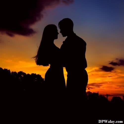 a silhouette of a couple kissing at sunset