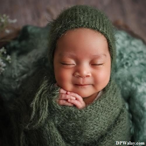 a newborn boy sleeping in a green blanket 
