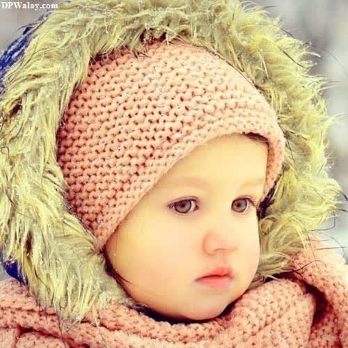 a baby wearing a knitted hat and scarf cute small girl dp for whatsapp