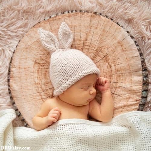 a baby wearing a bunny hat on a blanket images by DPwalay