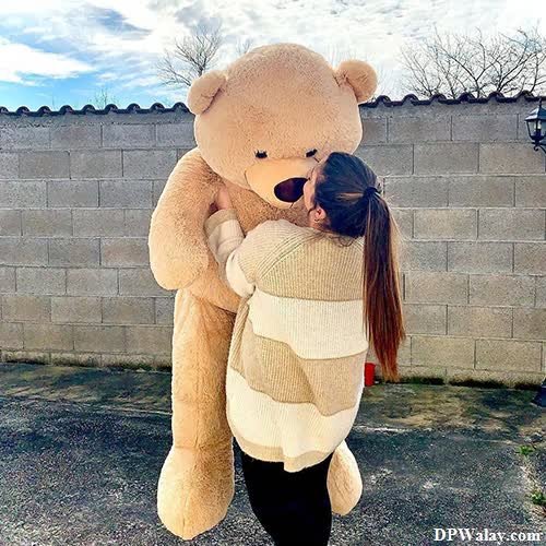 a woman hugging a large teddy bear