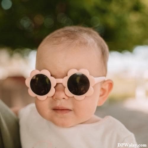 a baby wearing sunglasses with a white shirt 