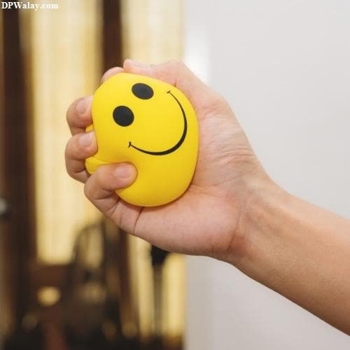a person holding a smiley face ball