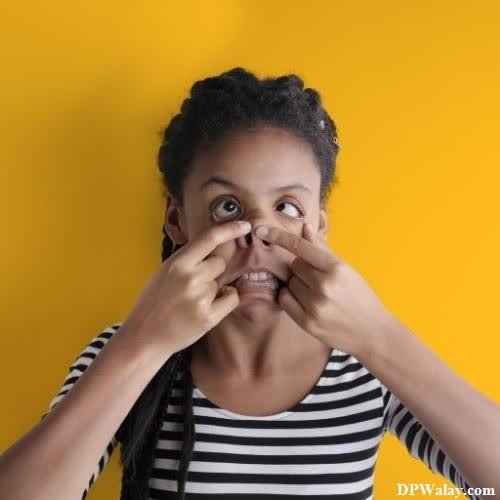 a young girl is covering her eyes with her hands