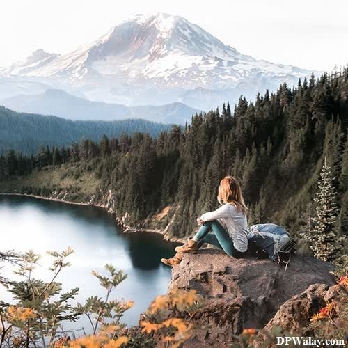 a woman sitting on a rock overlooking a lake lonely whatsapp dp 