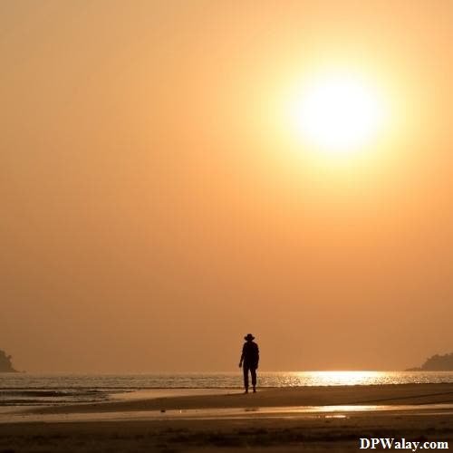 alone whatsapp dp - a man walking on the beach at sunset