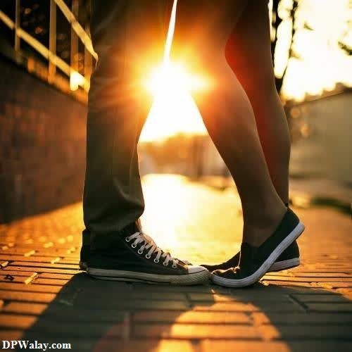a person standing on a sidewalk with the sun setting behind them love couple whatsapp dp