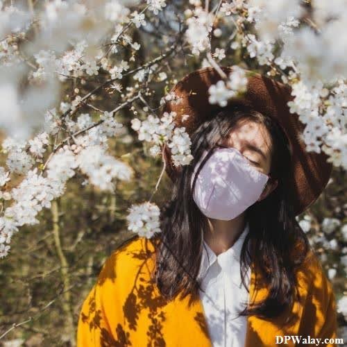 a woman wearing a mask in a field of flowers images by DPwalay