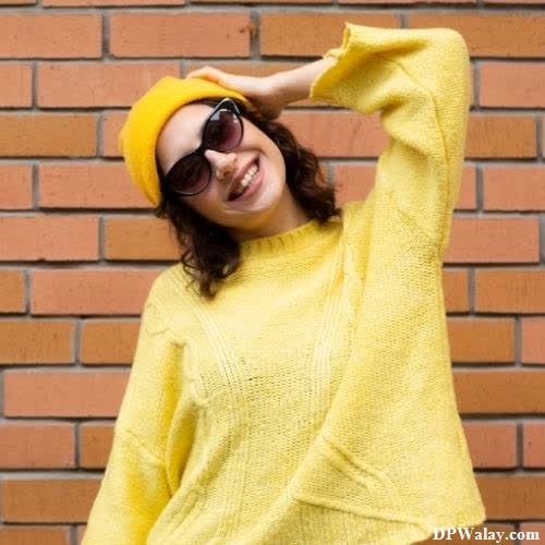 a woman in a yellow sweater and sunglasses images by DPwalay