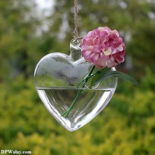 a heart shaped glass hanging decoration with a pink flower 