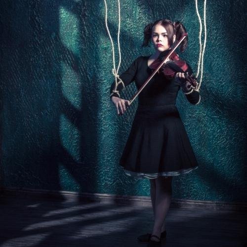 a girl in a black dress playing a violin