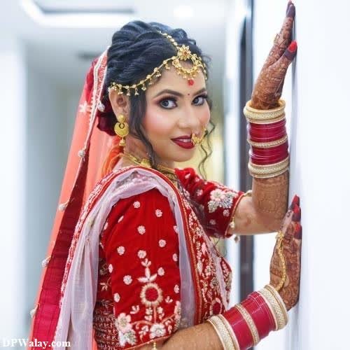 a bride in red and gold with her hands on her head images by DPwalay