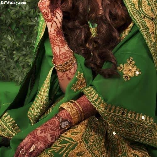 a beautiful woman in a green and gold sari