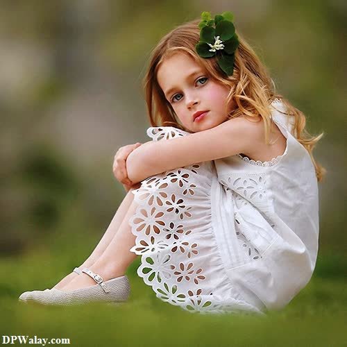 a little girl sitting on the grass