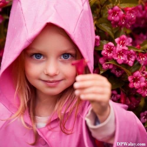 a little girl in a pink raincoat and hat
