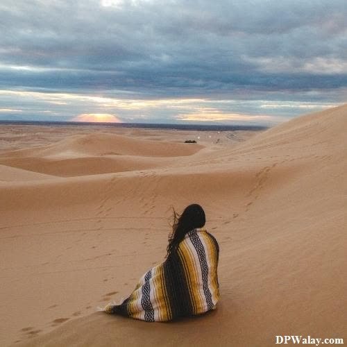 a woman sitting on top of a sand dune whatsapp alone dp 