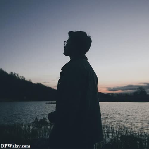 a man standing in front of a lake at sunset whatsapp alone dp 