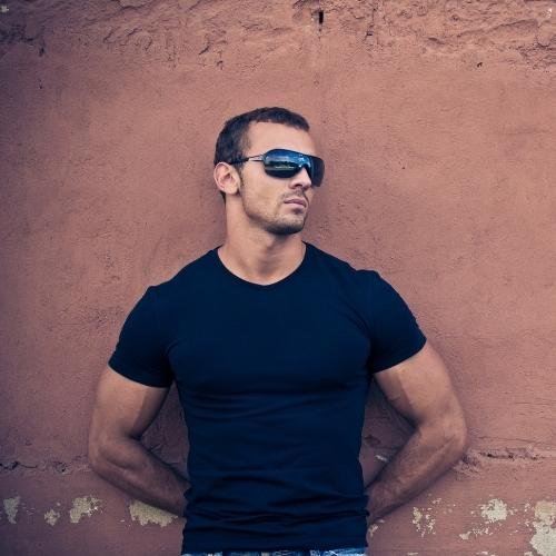 a man in sunglasses leaning against a wall