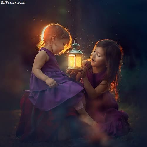two little girls sitting on the ground with a lantern in their hands
