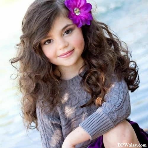 a little girl with long hair and a flower in her hair