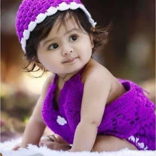 a baby girl wearing a purple dress and a white headband