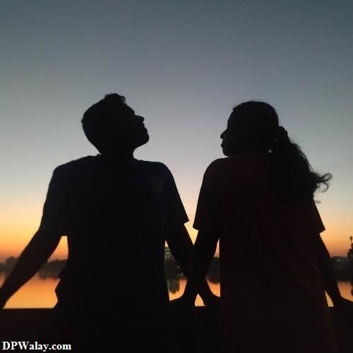 a couple holding hands and walking in the sunset