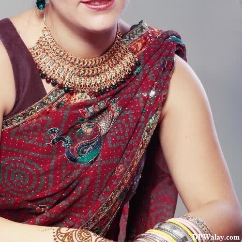 a woman in a red sari with a gold necklace