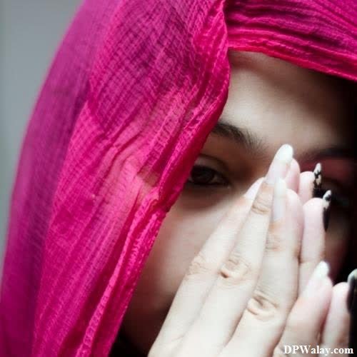 a woman in a pink veil covers her face with her hands